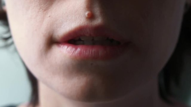 girl's mouth saying "I'm very sorry" close up half dark