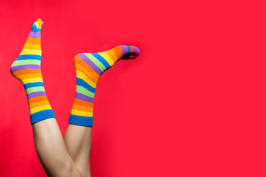 Legs in funny socks on bright red background