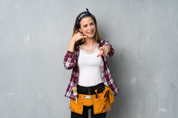 Craftsmen or electrician woman making phone gesture and pointing front