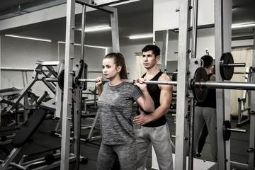 Fototapeta na wymiar Man instructor working with woman in gym