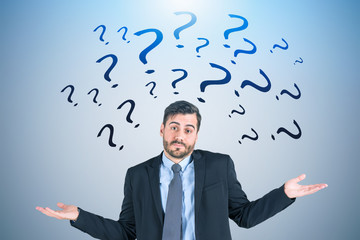 Shrugging shoulders businessman, question marks