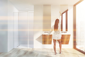 Woman in modern bathroom with shower and sink