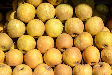 Group of yellow apple on an outdoor traditional peasant market, in direct sun light