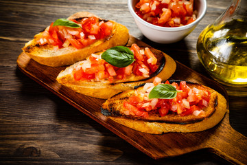 Bruschettas on cutting board on wooden background