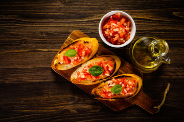Bruschettas on cutting board on wooden background