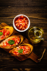 Bruschettas on cutting board on wooden background