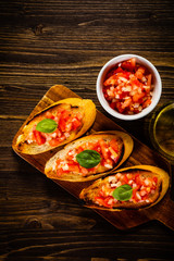Bruschettas on cutting board on wooden background