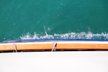 Turbulence made by foam of sea water from a high-speed yacht on surface of sea. Blue sea waves with lot of sea foam. Surface of sea with waves, splash, foam and bubbles, blue background and wallpaper.