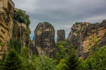 Fototapeta na wymiar dramatic steep rocks with forest trees at the foot Asian nature scenery landscape in cloudy weather time