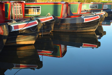 Fototapeta na wymiar Narrow boats moored at Wrenbury on the Llangollen canal, boats and reflections