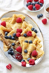 Crepes with fresh berries and raspberry marmalade. Thin pancakes with raspberry and blueberry. Overhead view
