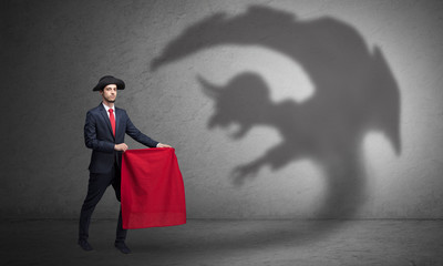 Businessman standing with red cloth in his hand and imp shadow on the background
