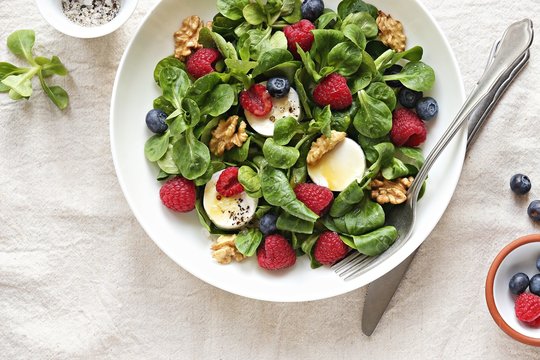 Green salad with goat cheese, walnuts,  fresh berries and lemon honey dressing