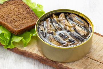 Canned sprats in tin can with bread for sandwich