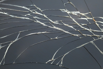 Abstract pattern dark gray background. Crackled screen of mobile cellphone. Gadget repair and maintenance concept.