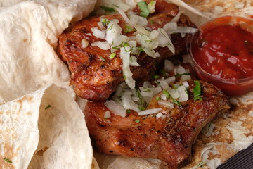 grilled ribs close up with ketchup on pita bread