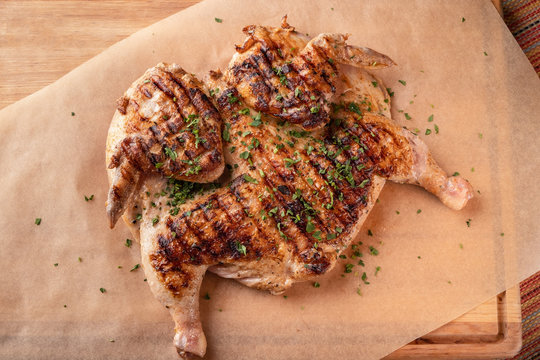 grilled chicken on a wooden board, close-up, top view