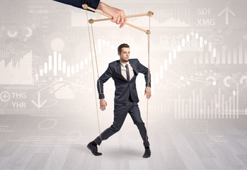 Puppet businessman controlled by another hand with financial concept
