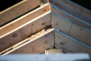 Close-up detail of roof frame of rough wooden lumber beams on background of misty mountain landscape in ecological area. Building, roofing, construction and renovation concept.