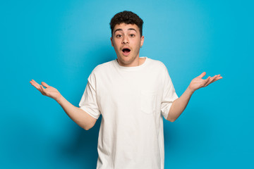 Young man over blue background with surprise and shocked facial expression