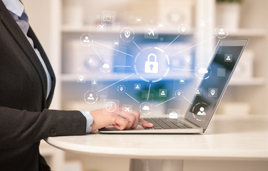 Business woman below chest working on laptop in a cozy homey environment with secured connection concept
