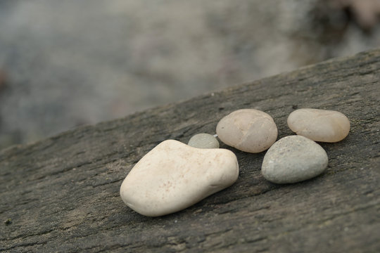 Zen pebbles on wooden bridge by waterside