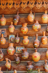 Fototapeta na wymiar Clay jugs on the timbered wall of village house closeup in sunny day
