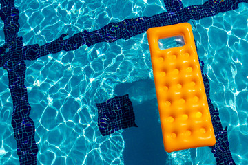 orange inflatable mattress in the pool
