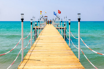 Obraz premium Love couple walks on the pier, leaving in the sea
