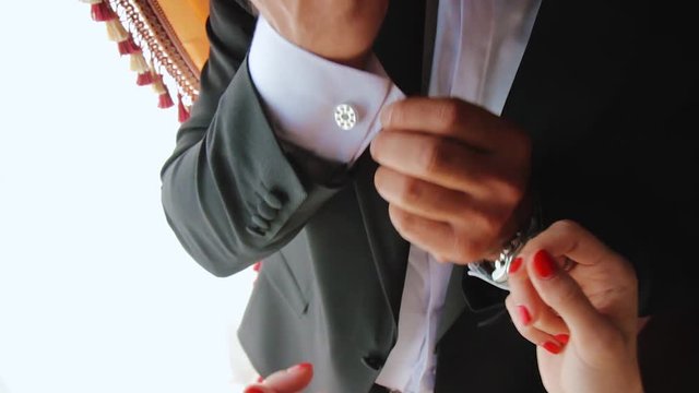 woman helps with cufflinks