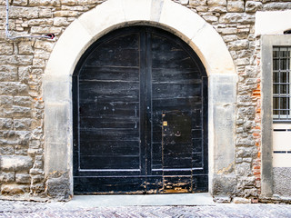 wide outdoor black wooden door in medieval house
