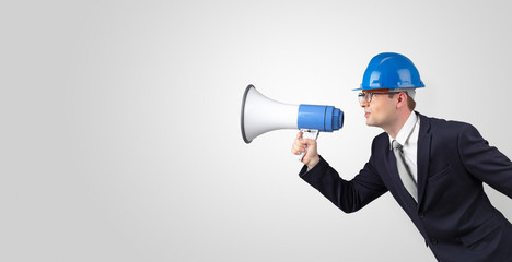 Fototapeta premium Young architect constructor yelling with megaphone and copyspace