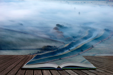 Stunning foggy English rural landscape at sunrise in Winter with layers rolling through the fields...