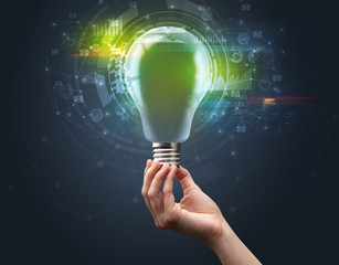 Hand holding light bulb on dark background. New business idea concept
