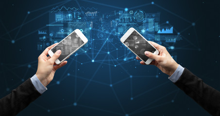 Close up of two hands holding smartphones to sync business data
