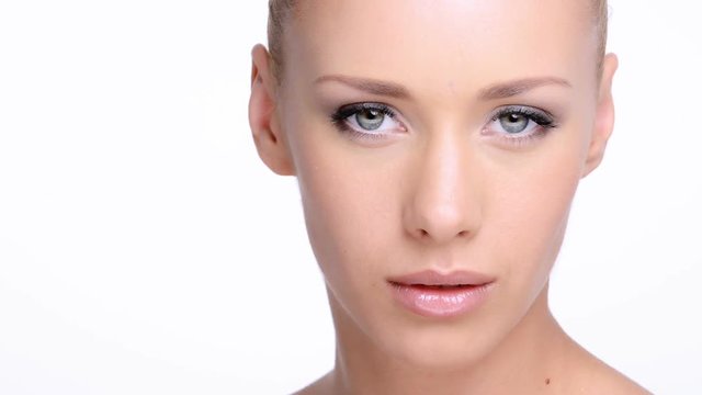 CLoseup face of an young woman with clean skin of a face. Healthy beautiful woman cares of face skin. Full Hd footage. Beauty treatments. Closeup portrait of young adult caucasian girl looks at camera