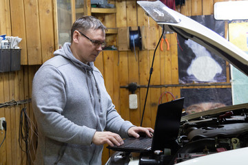 Mechanic using Diagnostic machine tools ready to be used with car