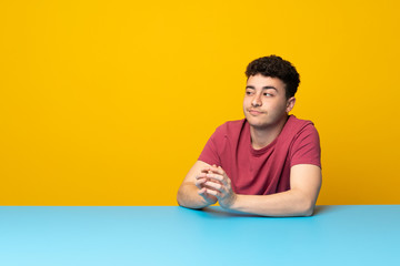Young man with colorful wall and table scheming something