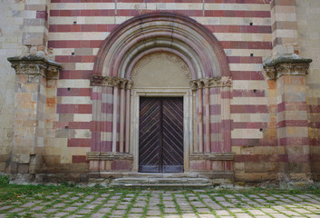 Gothic style door with red stone stripes and and arch (Hungary, Belapatfalva)