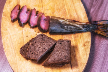 .Red fish on a cutting board, with spices, black bread.