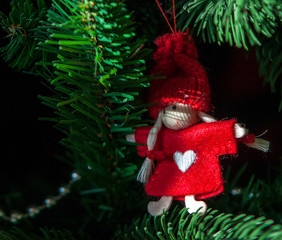 Closeup of red toy hanging from a decorated Christmas tree