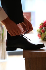 Bräutigam bindet Schuhe zu 
