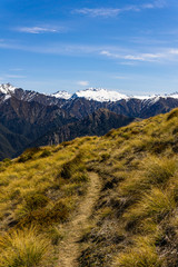 idillic landscape with mountain range, brown hills during sunny day, perfect hiking area, footpath leading into mountains 