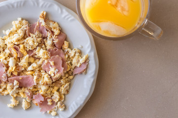 Top view of scrambled eggs and orange juice