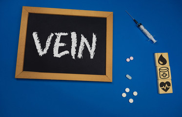 wooden tablet on blue medical table with the word VEIN