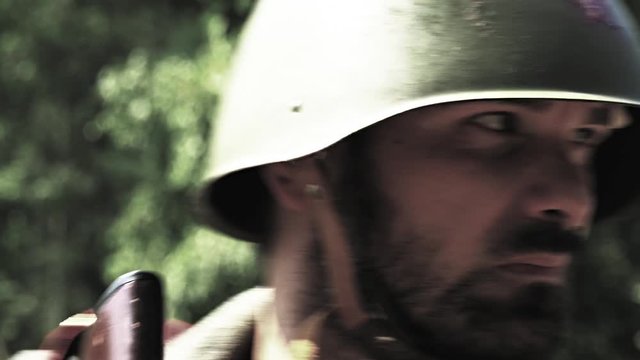 Soldier is aiming while other soldiers passing