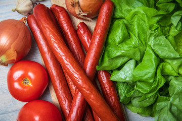 Traditional homemade smoked sausage for barbeque with fresh organic vegetable in the background