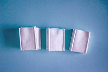 Cotton wipes for removing makeup. Five-layer cotton cosmetic wipes. Cotton napkins for the face. Close-up on a blue background