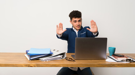 Business man in a office making stop gesture and disappointed