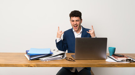 Business man in a office making rock gesture